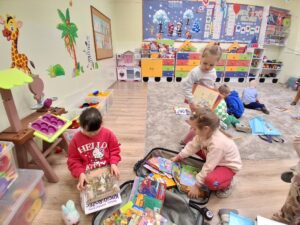 przedszkolaki wybierają książki z kolorowej walizki