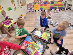 przedszkolaki wybierają książki z kolorowej walizki