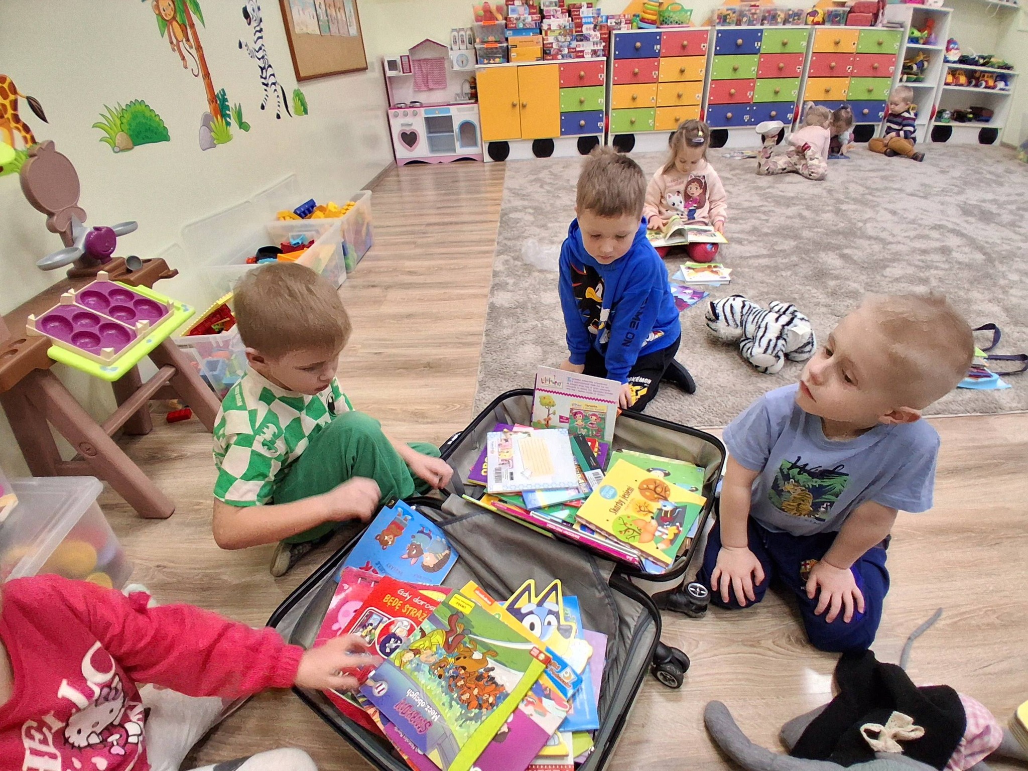 przedszkolaki wybierają książki z kolorowej walizki