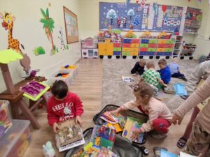 przedszkolaki wybierają książki z kolorowej walizki