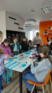 dzieci splatają sznurek do makramy