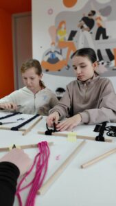 dzieci splatają sznurek do makramy