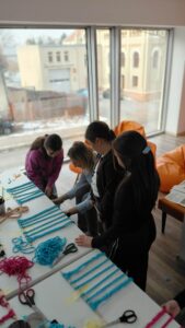 dzieci splatają sznurek do makramy