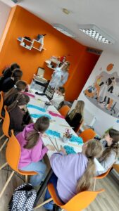 prowadząca pokazuje splot makramowy