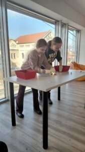 dziewczynki próbują przenieś pianki za pomocą kubeczków