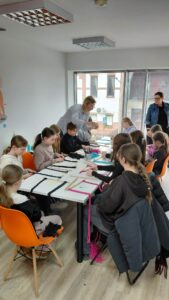 dzieci splatają sznurek do makramy