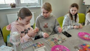 dzieci nawlekają koraliki