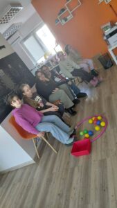 dzieci przy użyciu stóp przenoszą kolorowe piłeczki