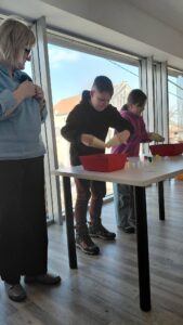 dzieci próbują przenieś pianki za pomocą kubeczków