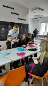 dzieci splatają kolejną część ramki