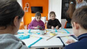 dzieci splatają kolejną część ramki