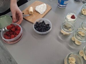 dziewczynka wkłada owoce do słoiczków