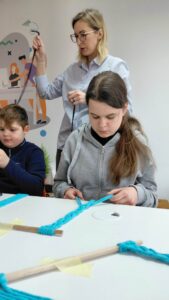 dzieci splatają kolejną część ramki