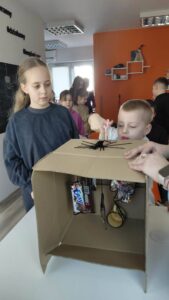 dzieci próbują przeciąć linę z nagrodą