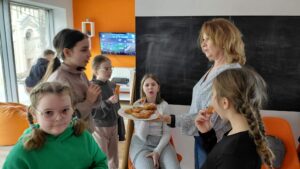 bibliotekarka częstuje dzieci faworkami