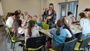 prowadzący pokazuje dzieciom jak zrobić pracę