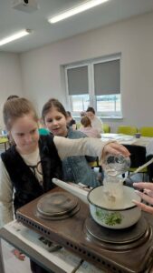 dzieci dolewają wodę do rozpuszczającego się mydła