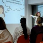 prowadząca objaśnia coś widowni