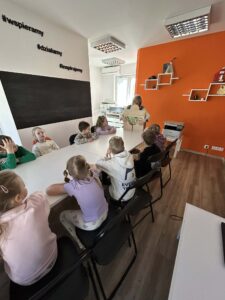 bibliotekarz czyta dzieciom bajkę w teatrzyku kamishibai