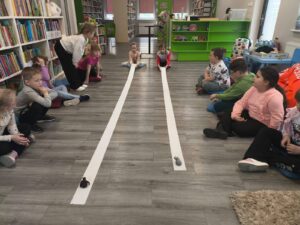 dwoje dzieci przyciąga zwierzątko na papierze