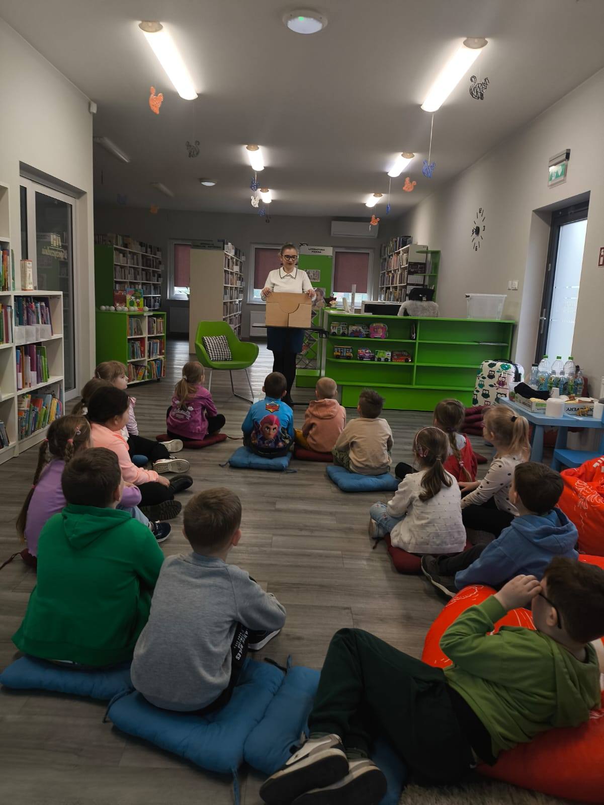 dzieci czekają na otwarcie teatrzyki i czytanie bajki