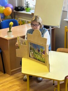 bibliotekarz czyta bajkę w teatrzyku kamishibai