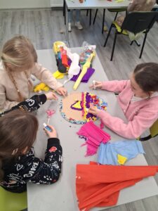 dziewczynki wyklejają pisankę