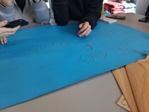 dziewczynki tworzą napis na plakacie