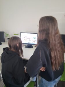 dziewczynki szukają potrzebne ilustracje w komputerze