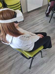 dziewczynka siedzi na krześle i ma założone gogle