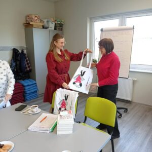 prowadzący wręcza klubowiczom torby ekologiczne na książki