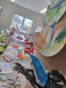 dzieci kolorują kwiatki i motylki