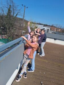 dziewczynki stoją przy balustradzie na dachu czytelni letniej