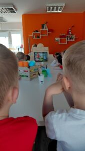 dzieci słuchają bajki w teatrzyku kamishibai