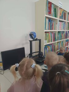 dzieci obserwują jak działa drukarka 3d