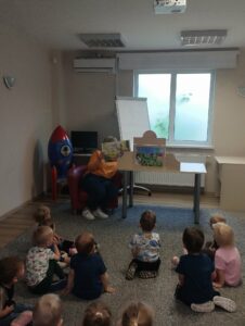 dzieci słuchają bajki w teatrzyku kamishibai