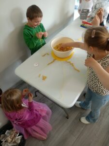 dzieci nawlekają makaron na nitki
