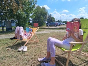 dzieci na leżakach czytają książki