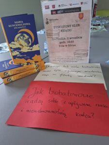 zdjęcie stosu książek i plakatu zapraszającego na dkk