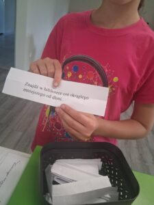 dziewczynka trzyma kartkę z zadaniem do wykonania